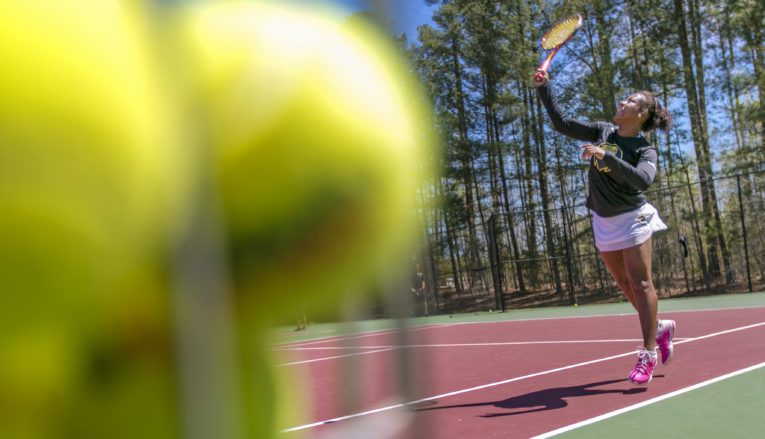 Student playing tennis
