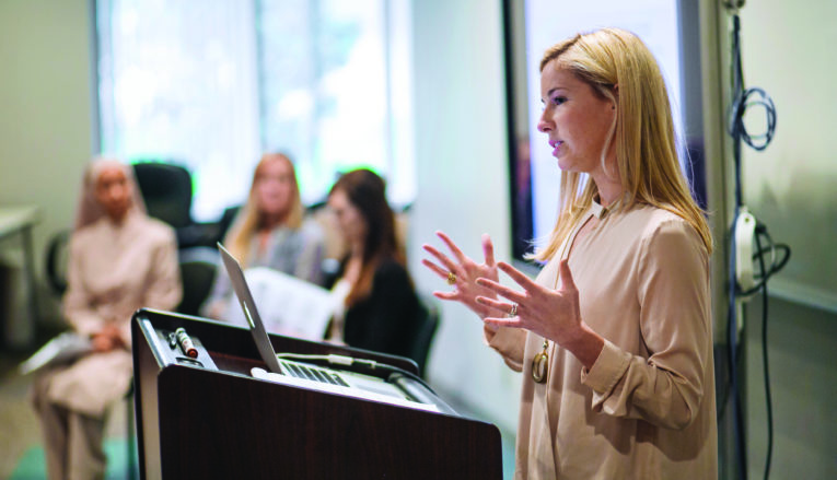 Professor speaking from podium during class